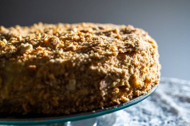 Meşhur Napolyon keki. Fırında pişirilmiş ve cam sepetinde servis edilmiş. Yandan gelen güneş ışığıyla aydınlatılan gevrek parçacıklarla süslenmiş.
