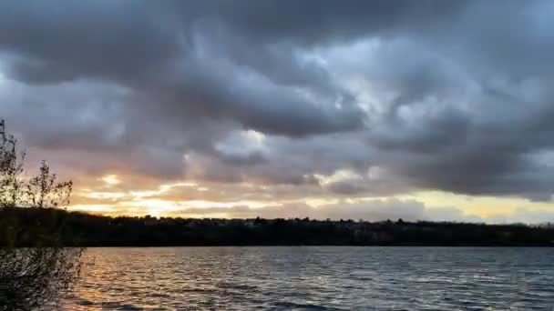 前景の植生と水平線上に積乱雲と農村シーン 日没時の水の上の雲の動きの崩壊 — ストック動画