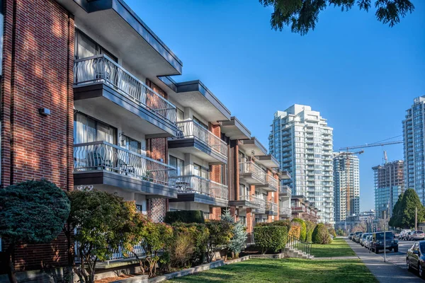 Önünde yeşil çimlerin olduğu apartman binaları..