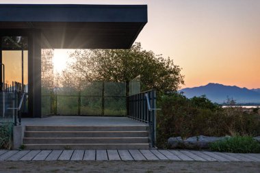 Closed beach cafe in sunset light rays.