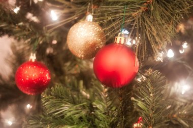 Elektrik lambaları halesindeki renk topları yapay Noel ağacı süslüyor.