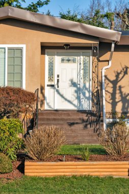 Kışın güneşli bir günde, kapısı olan bir evin ana girişi.