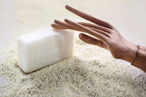 Wooden hand on piece of soap — Stock Photo, Image