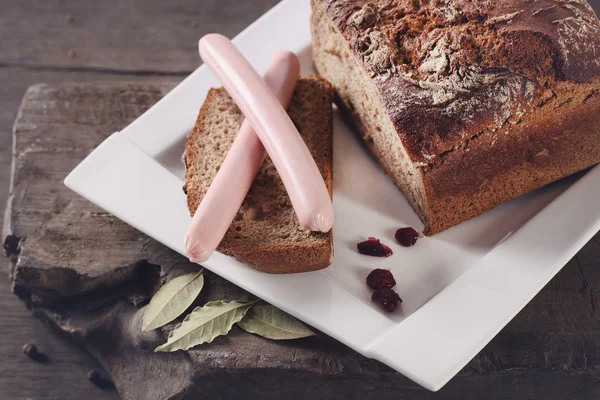 Pain noir et saucisse dans une assiette — Photo