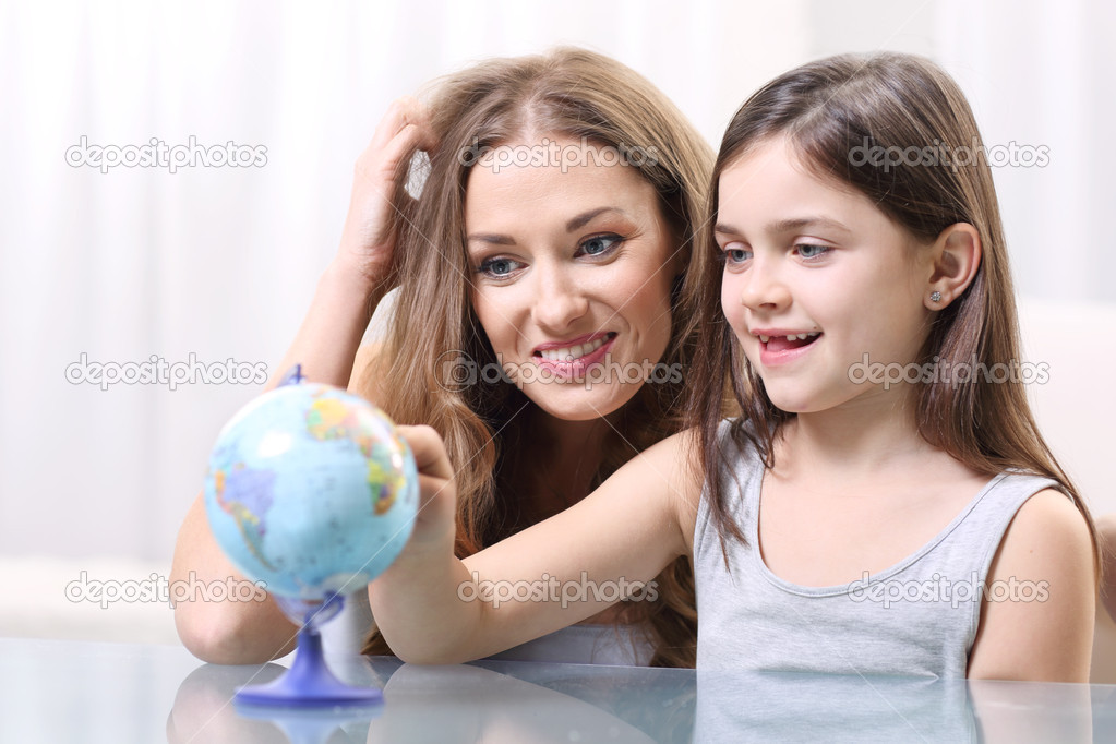 Mother and daughter looking at a globe