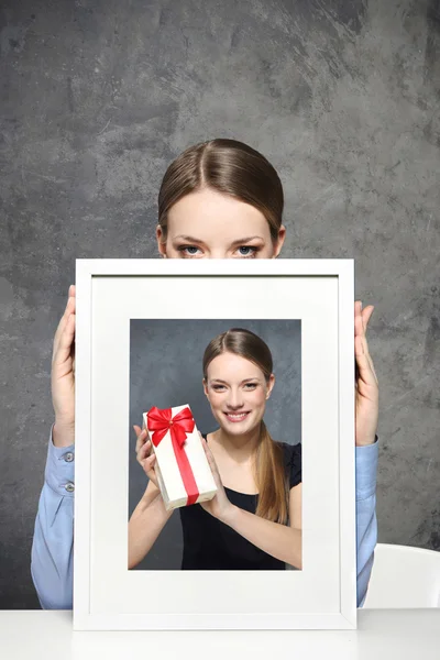 Tjej innehar en bild — Stockfoto