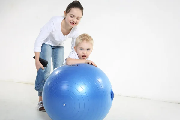 Irmão e irmã posando com uma bola — Fotografia de Stock