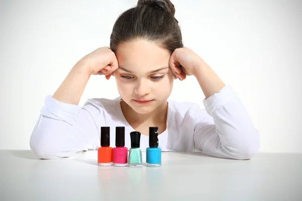 Little girl and nail polishes — Stock Photo, Image