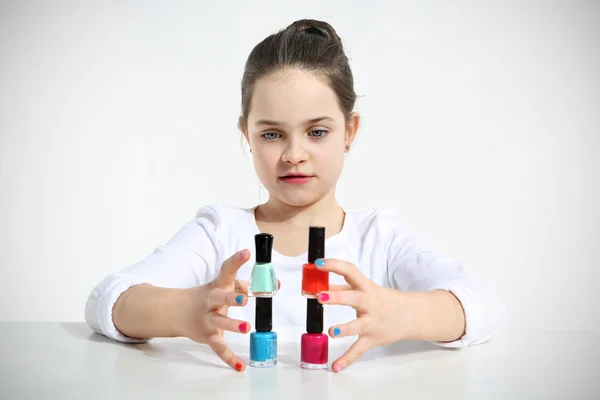 Little girl builds a pyramid using nail polishes — Stock Photo, Image