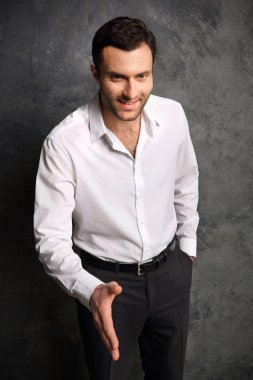 gömlekli bir adam elinde siyah bir arka plan üzerinde verir.