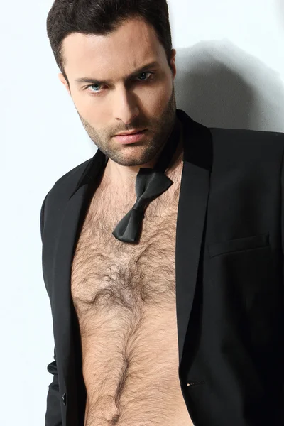 Great looking sexy male model with open shirt and loose bow tie — Stock Photo, Image