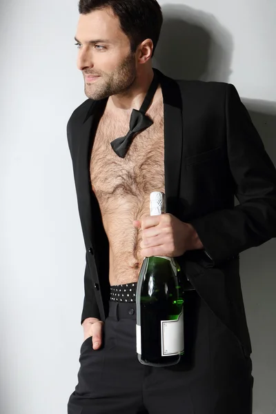 Sexy mužský model drží láhev šampaňského — Stock fotografie