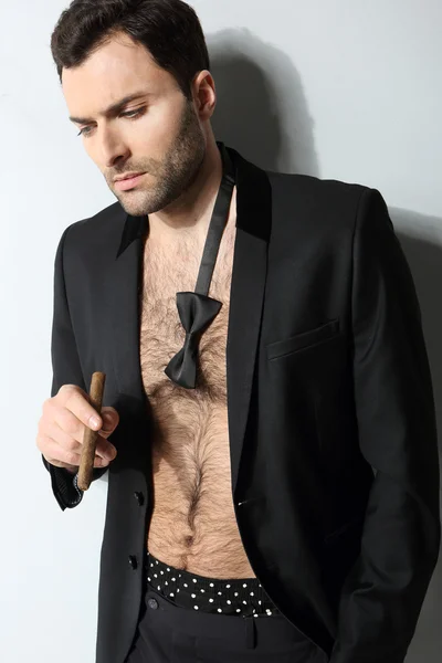 Sexy male model smoking cigar in open formal attire — Stock Photo, Image