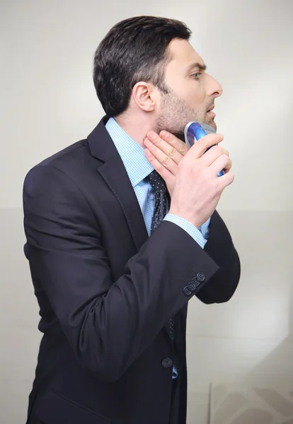 Young man shaving with electric razor — Stock Photo, Image