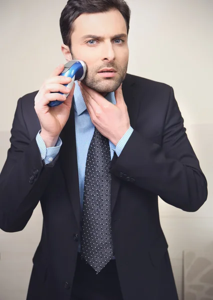 Young man shaving with electric razor — Stock Photo, Image