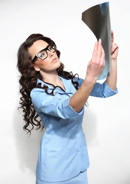 Vrouwelijke arts kijken naar een x-ray blad — Stockfoto