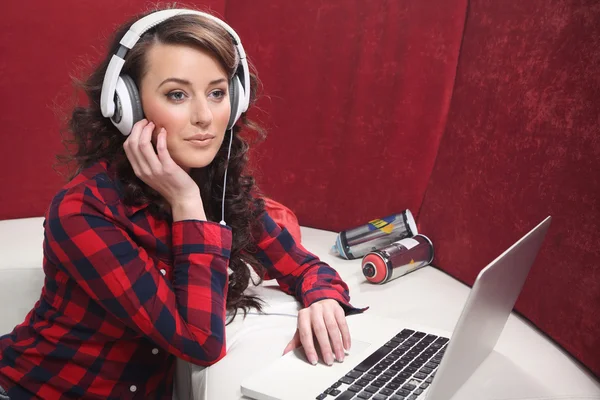 Jong meisje met laptop luisteren naar muziek — Stockfoto