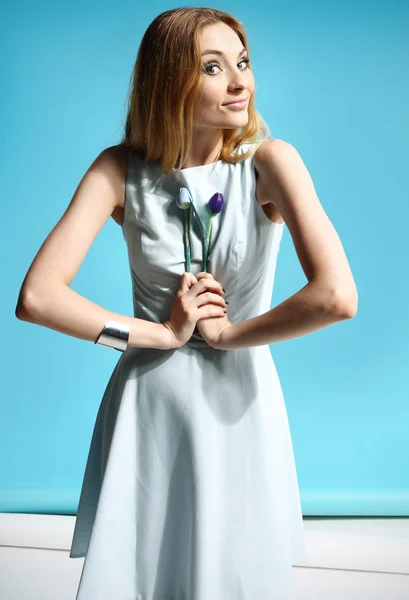 Menina bonita em um vestido branco segurando uma flores — Fotografia de Stock