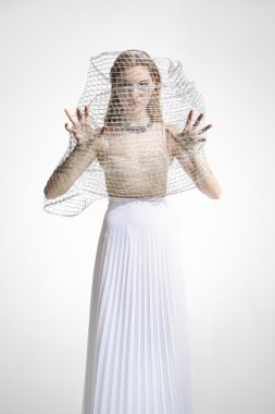 Beyaz elbiseli güzel kız bir kafes ile kaplı