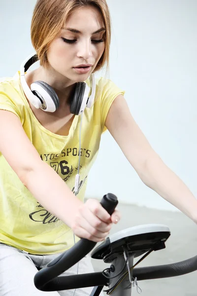 Young girl on stationary bike — Stock Photo, Image