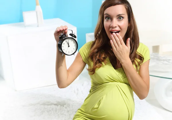 Mujer embarazada con un despertador — Foto de Stock
