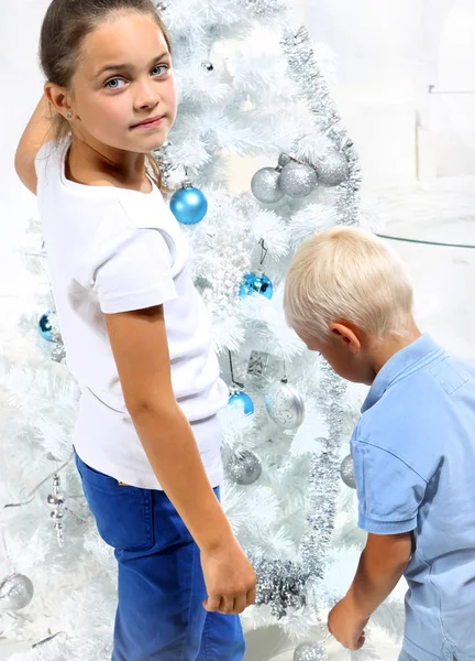 Broer en zus versieren de kerstboom — Stockfoto