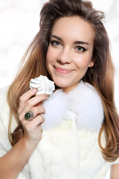 Ragazza sorridente in pelliccia bianca con meringa — Foto Stock