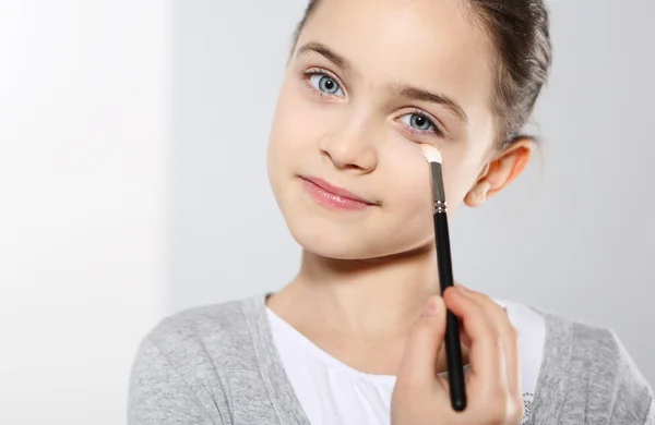 A teenage girl applying eye shadow — Stock Photo, Image
