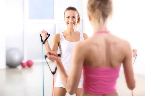 Two young women exercise the back muscles — Stock Photo, Image