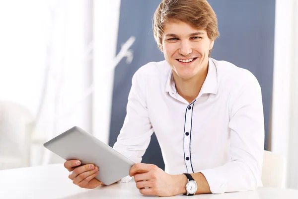 Trabajando detrás de un escritorio, un joven empleado guapo — Foto de Stock