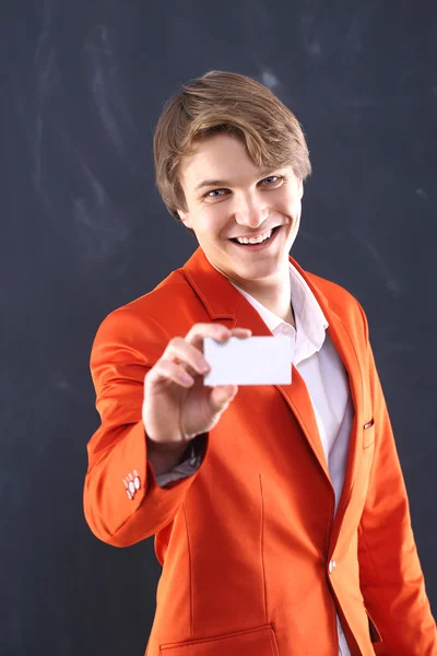 Fröhlicher Junge in orangefarbener Jacke mit weißer Vitrine — Stockfoto