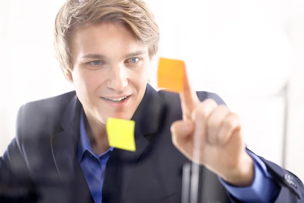 Joven director en traje azul poniendo notas — Foto de Stock