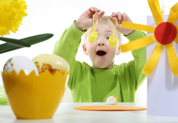 Green Easter - a little boy decorates Easter eggs — Stock Photo, Image