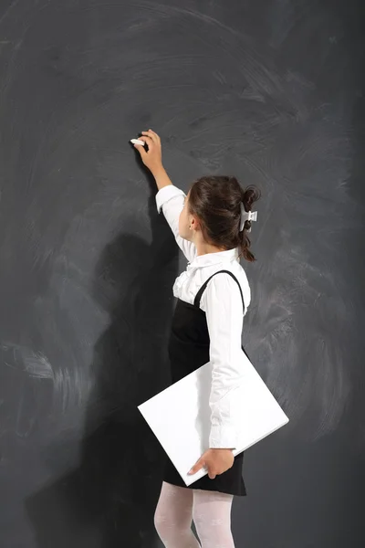 Schoolgirl writes on the blackboard — Stock Photo, Image