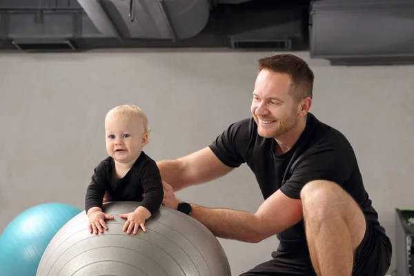 子供の理学療法とリハビリテーション ボールの上の赤ん坊と理学療法士の練習 — ストック写真