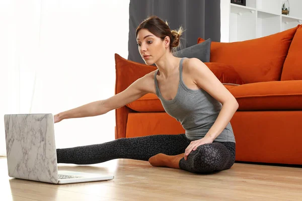 집에서의 온라인 여자가 온라인 트레이너와 거실에서 훈련하고 스톡 이미지