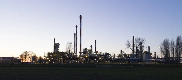 Uma refinaria de petróleo ao pôr do sol — Fotografia de Stock