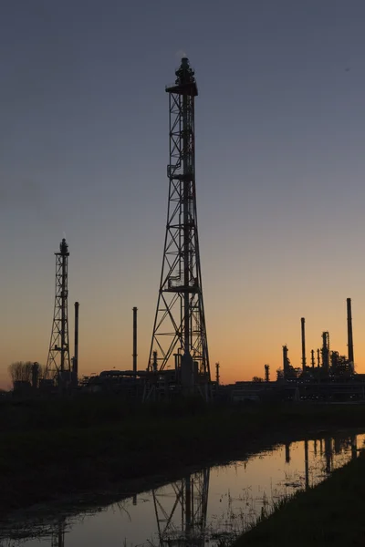 Uma refinaria de petróleo ao pôr do sol — Fotografia de Stock