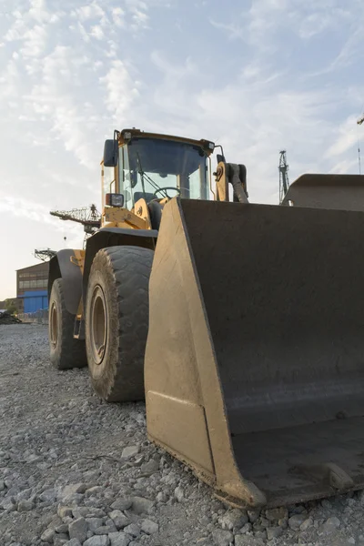 Grote bulldozer met de scheepswerf op de achtergrond — Stockfoto