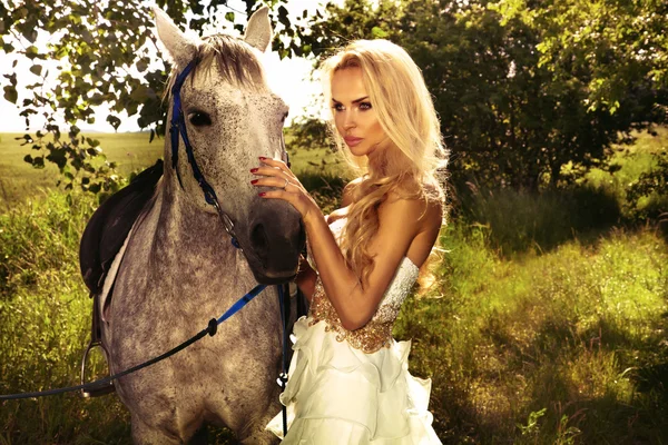 Linda senhora loira com posando com cavalo . — Fotografia de Stock