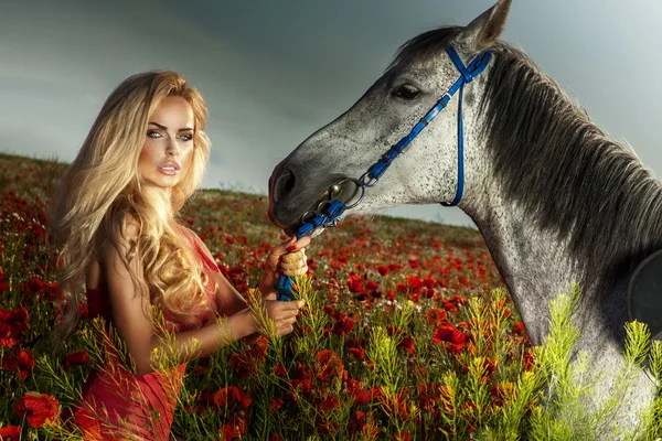 Ελκυστική ξανθιά γυναίκα που ποζάρει με άλογο — Φωτογραφία Αρχείου
