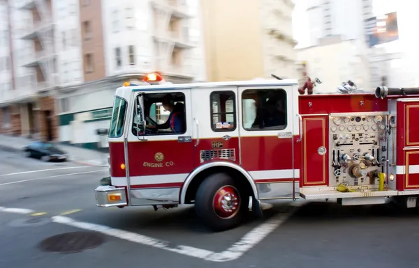 Пожежна машина у великому місті Стокове Фото
