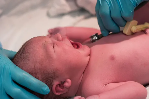 Νεογέννητο μωρό που υποβάλλεται σε έλεγχο από νοσοκόμα Εικόνα Αρχείου