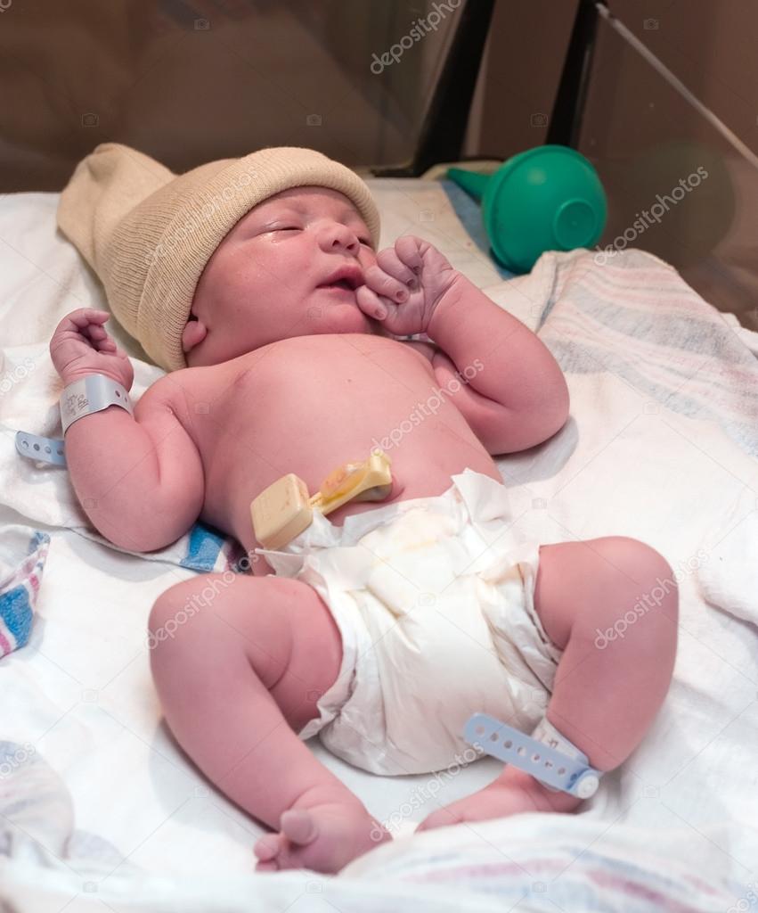Newborn resting in hospital bassinet