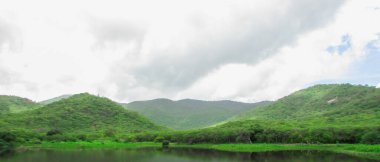 Lake at the foot of the mountain with a beautiful forest green blue sky and beautiful clouds, paisagen of brazil