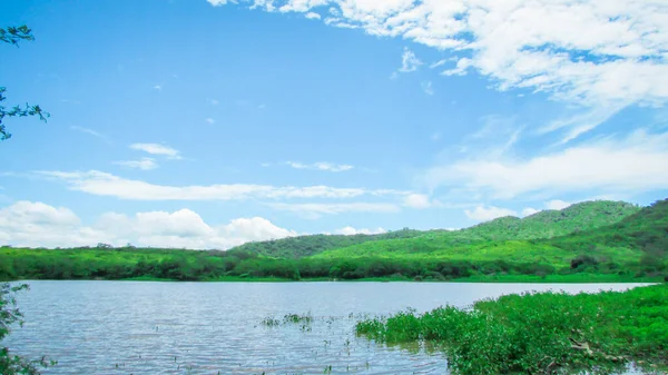 Lake at the foot of the mountain with a beautiful forest green blue sky and beautiful clouds, paisagen of brazil