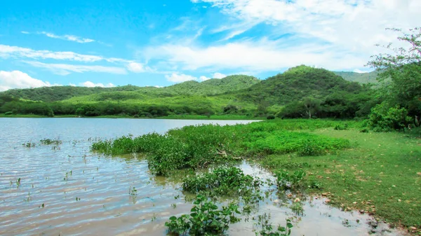 Lake at the foot of the mountain with a beautiful forest green blue sky and beautiful clouds, paisagen of brazil