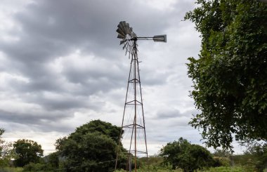 Sanatsal arkaplanda doğal manzara oluşturan metal hidrolik rüzgar gülü