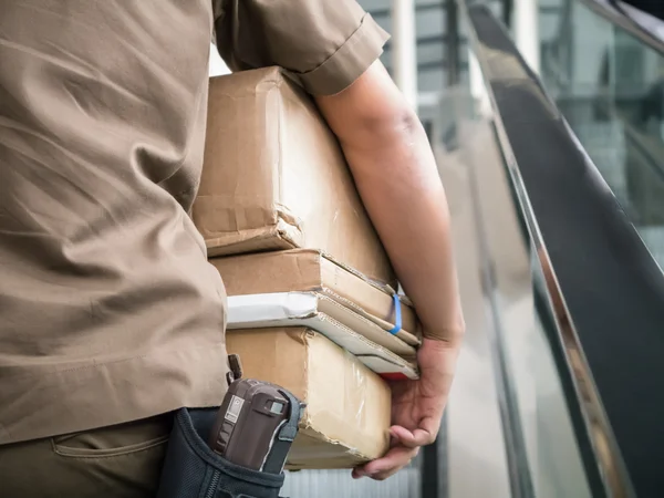 Postbote trägt Pakete — Stockfoto