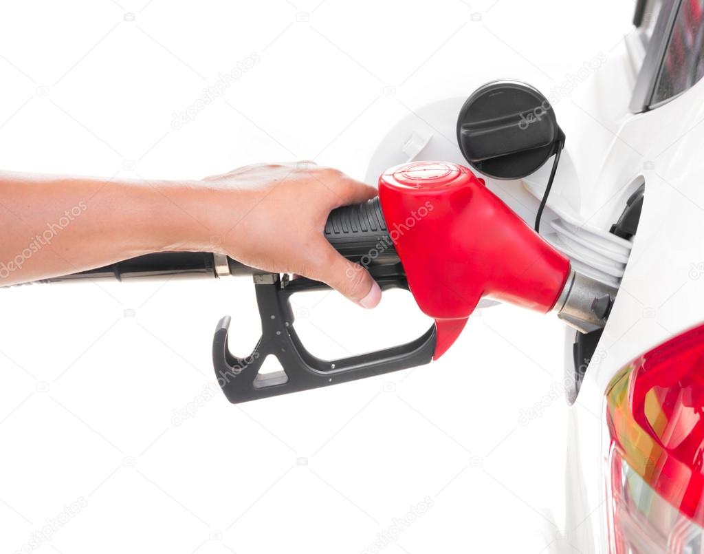 Hand holding gasoline nozzle filling up a car isolated on white